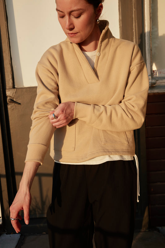Fleece Popover in Buttermilk, front view with the collar open and hem drawcord loose, worn over the Uniform Tee in White